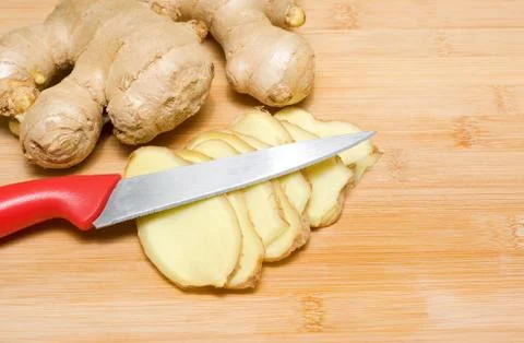 Ginger root on a bamboo chopping block Foto stock