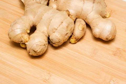 Ginger root on a bamboo chopping block Stock Photos