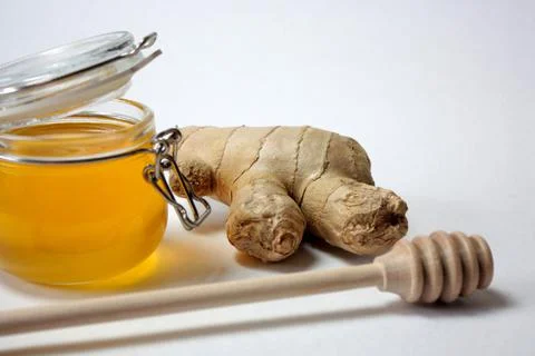 The ginger root in the center of composition on a white background. Stock Photos