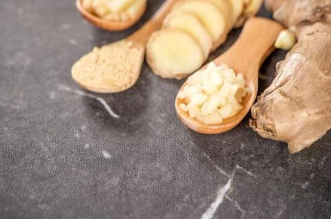 Ginger root, ginger slice and ginger powder on stone background table, space  Stockfoto's