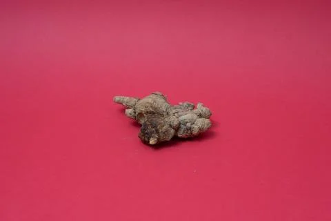 Ginger root isolated on red background Stock Photos