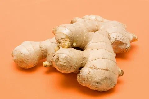 Ginger root on orange background Stock Photos