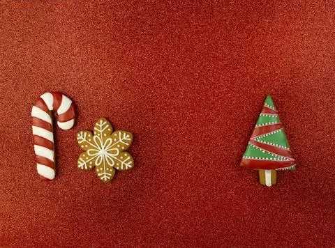 Ginger snowflake, candy and Christmas tree on a red background. Stock Photos