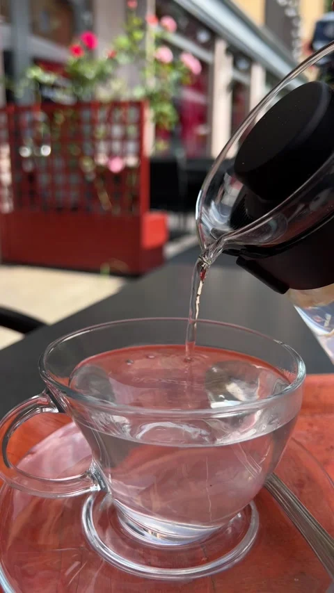 Ginger tea being poured in a transparent cup in street cafe. Vertical video Stock Footage 246355895
