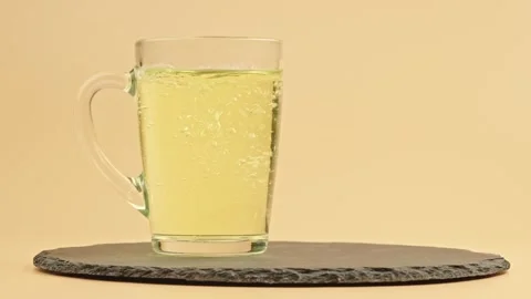 Ginger tea. Glass mug filled with hot herbal tea on a black stone tray Stock Footage 318885918