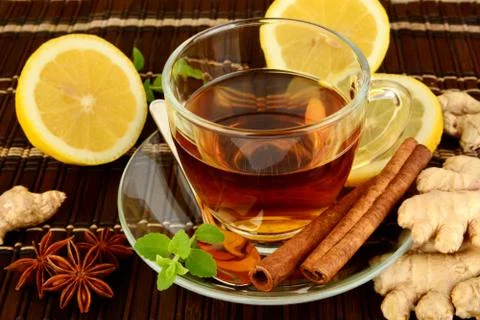 Ginger tea-ingwertee on brown mat with lemon,cinnamon,anise and mint on mat Foto stock