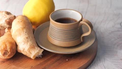 Ginger tea with lemon and fresh root on wooden board cinematic footage of h.. Stock Footage 333158512
