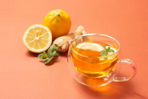 Ginger tea with mint and lemon. Healthy drink. Crystal cup on bright background Stock Photos