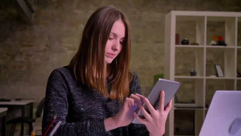 Ginger young girl using pad and showing the blue display to camera and then Video stock 99238911