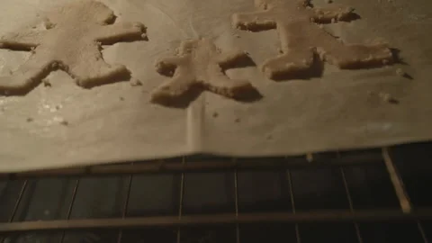 Gingerbread biscuits being put into oven Stockbeeldmateriaal 336374431