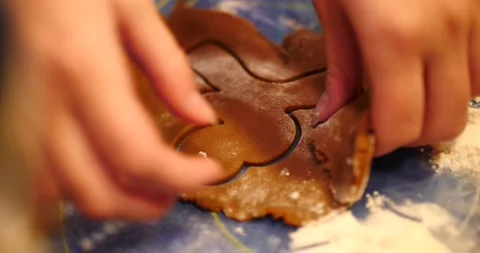 Gingerbread cookie being cut out of cookie dough close up of gingerbread man Video stock 217358336