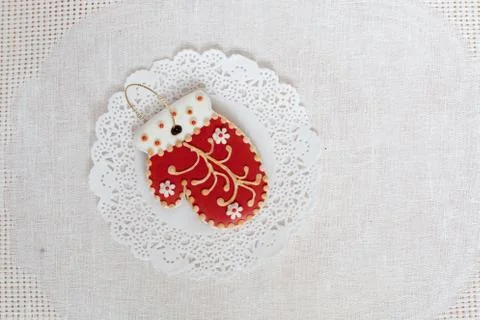 Gingerbread cookie in the shape of red mitten on a white napkin background. Top Stock Photos