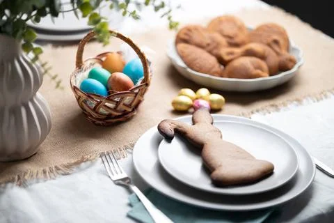 Gingerbread cookie shaped as Easter bunny on plate at decorated table Stock Photos