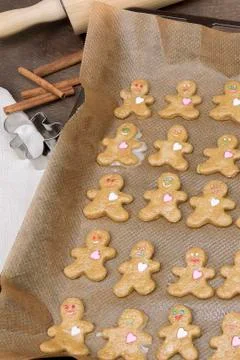 Gingerbread cookie smiling man on baking paper on a baking sheet, vertical Stock Photos