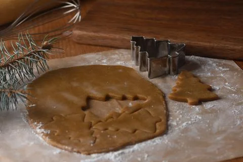 Gingerbread cut from a layer of dough on baking paper Stock Photos