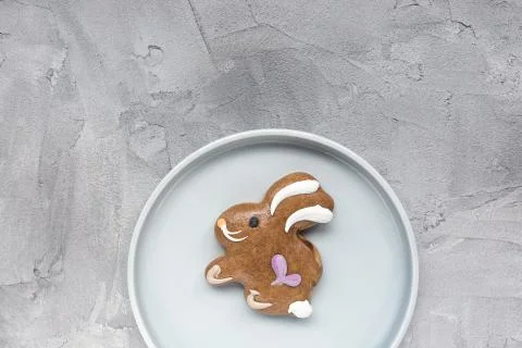 Gingerbread easter bunny cookie on a plate on a gray background. Easter conce Stock Photos