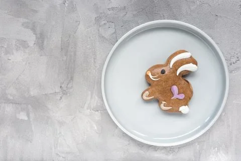 Gingerbread easter bunny cookie on a plate on a gray background. Easter conce Foto stock