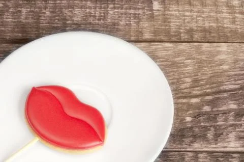 Gingerbread in the form of red lips, lying on a plate 库存照片