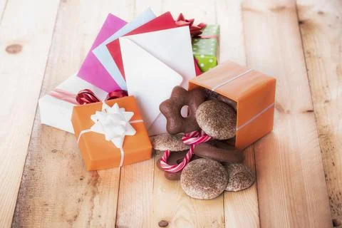 Gingerbread in a gift box near a stack of gifts and multicolored envelopes Foto stock
