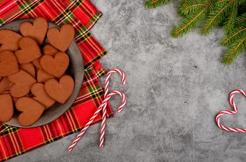 Gingerbread heart on a black clay plate and Christmas decorations .Gray concrete Stock Photos