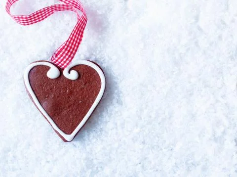 Gingerbread heart on snow Stock Photos