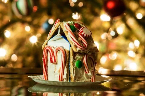 Gingerbread house against a background of christmas tree lights Stock Photos