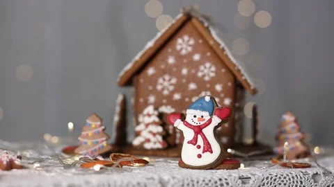 Gingerbread house on the background of lights, snowman and Christmas tree Stock-Footage 70791103