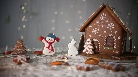Gingerbread house on the background of lights, snowman and Christmas tree Stock-Footage 70791207