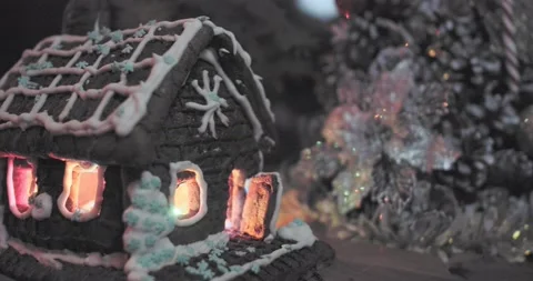 Gingerbread house with luminous windows on the background of the Christmas tree. Stock Footage 171718822