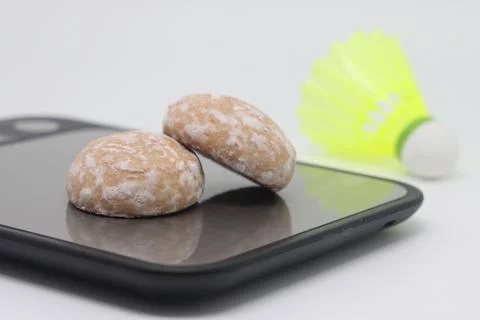 Gingerbread on a kitchen scale against the background of a shuttlecock. Calor Stock Photos