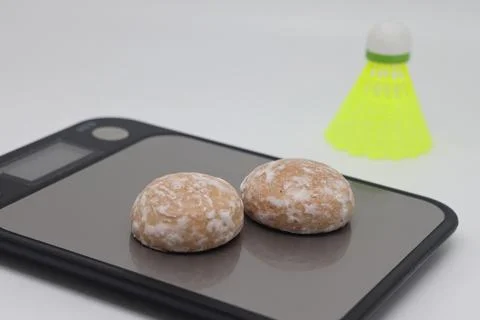 Gingerbread on a kitchen scale against the background of a shuttlecock. Calor Stock Photos