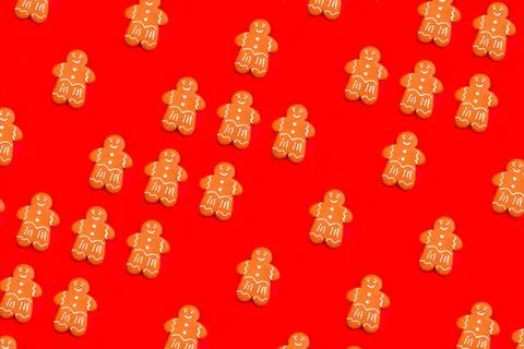 Gingerbread man pattern on bright red festive background. Tasty homemade Chri Stock Photos