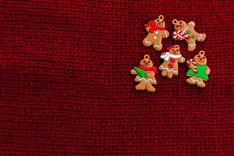 Gingerbread men on red knitted background. Christmas three decorations or New Foto stock