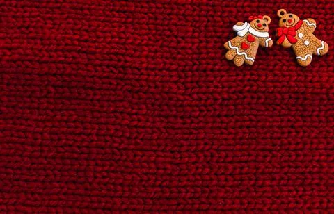 Gingerbread men on red knitted background. Christmas three decorations or New Stock Photos