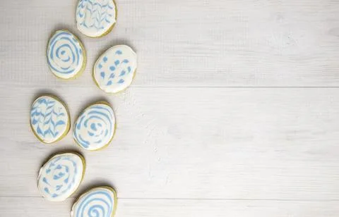 Gingerbread in sugar glaze in the shape of Easter eggs on a white wooden Stock Photos