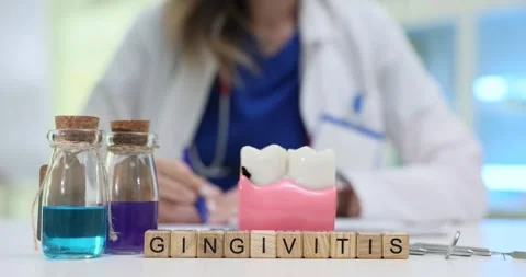 Gingivitis on blocks and teeth with gums near doctor writing note Stock Footage 314113634