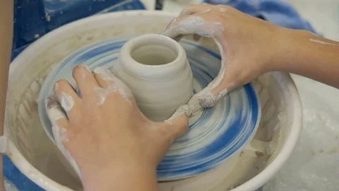 On girder circle teacher helps student to make a pitcher of clay. Stock Footage 79861925