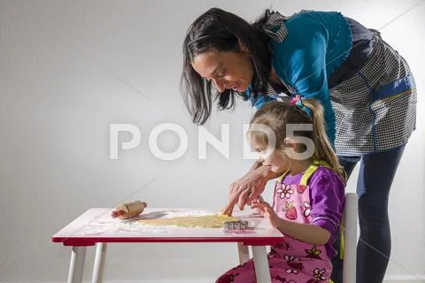 Girl 3 years and her mother baking Christmas cookies Stock Photos