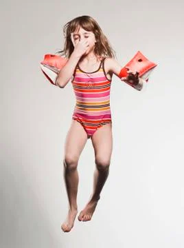 Girl (7-8) wearing armband and jumping Stock Photos
