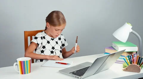 Girl 7-8 years holding a chocolate tile and sweeps the crumbs off the table Stock Footage