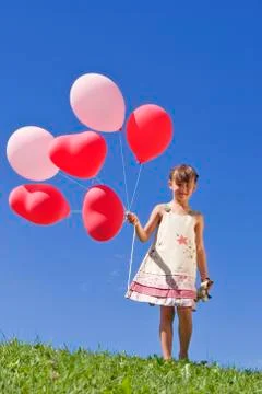 Girl (7-9) holding bunch of ballons Stock Photos