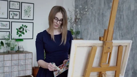 Girl adding colors on pallette Stock Footage 74640708