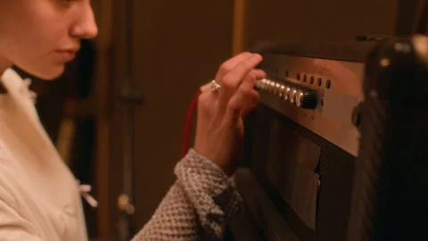 Girl Adjusting Knobs on Amplifier, Preparing for Performance in Music Studio 스톡 동영상 305852109