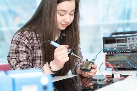 	The girl adjusts the electronics system on the microprocessor 스톡 사진