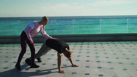 The girl aggressively teaches the guy to do the exercises correctly Stock Footage 143035599