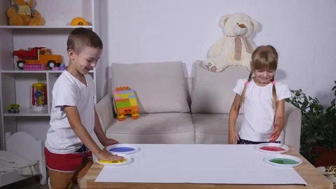 A girl and a boy leave their handprints on the paper, time lapse Stock Footage