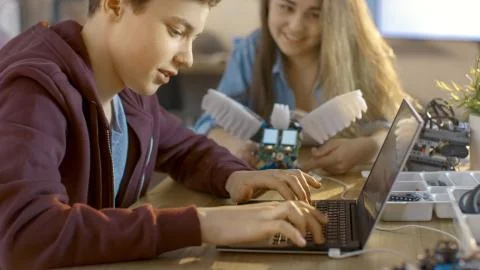 Girl and Boy Program Fully Functional Robot with Laptop For Their Science/ Ro Stock Photos