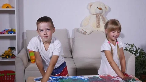 Girl and boy show hands in paint Stock Footage