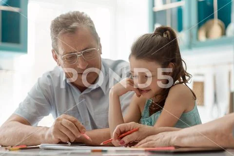 Girl and grandpa drawing. Family, indoor activity Stock Photos