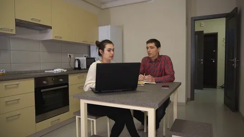 Girl and guy are talking family business sitting in front of the laptop Stock Footage